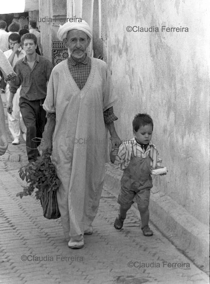 A Man & Boy Walking In A Souk 